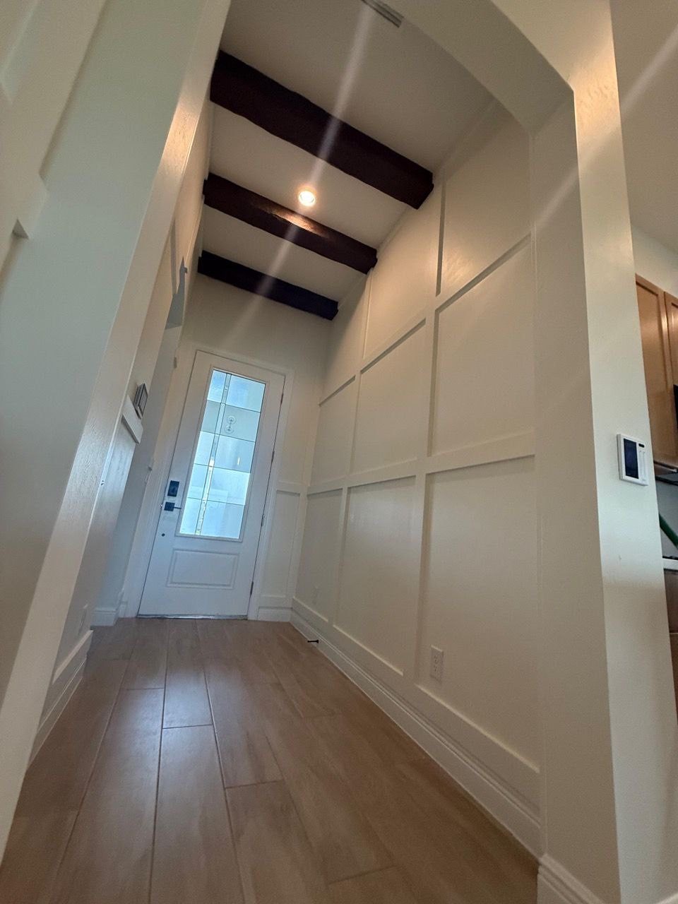Entryway with board and batten trim and wood ceiling beams