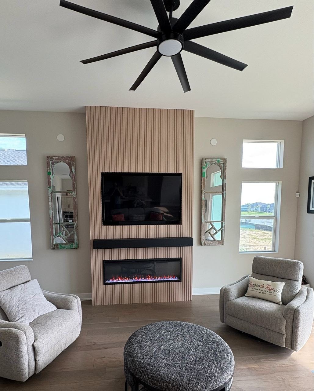 Fluted wood accent wall with fireplace and ceiling fan