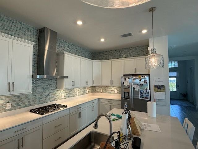 Kitchen with custom range hood and tile backsplash