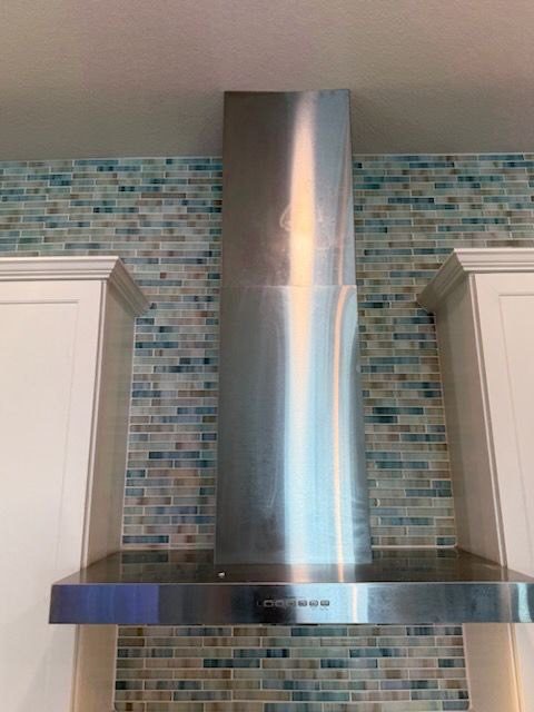 Stainless range hood with mosaic tile surround