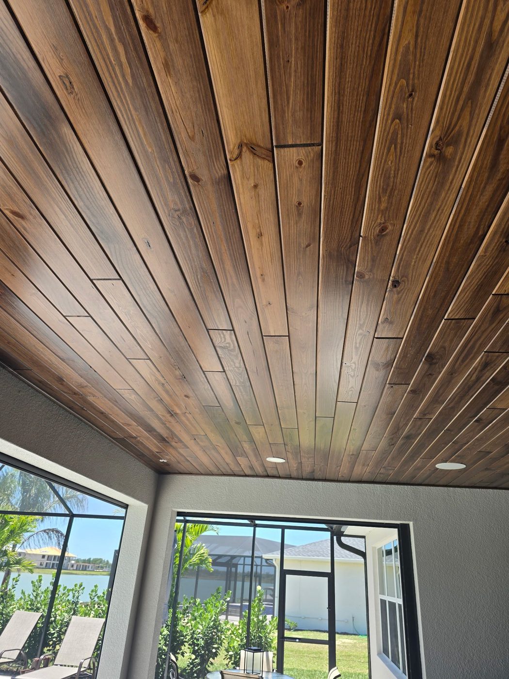 Stained tongue and groove wood ceiling on a lakefront lanai